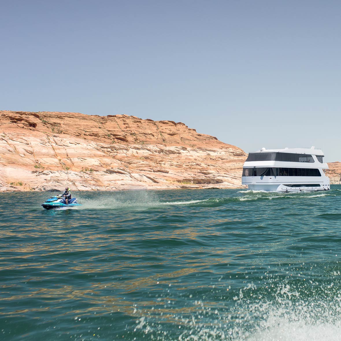 Jet skiing across Lake Powell with the houseboat nearby.