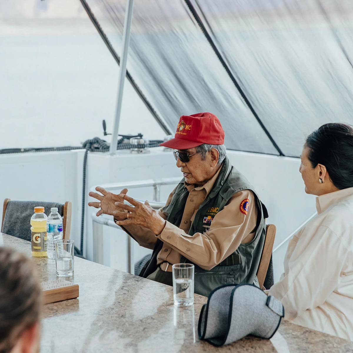 A Navajo code talker speaks to a group of friends.