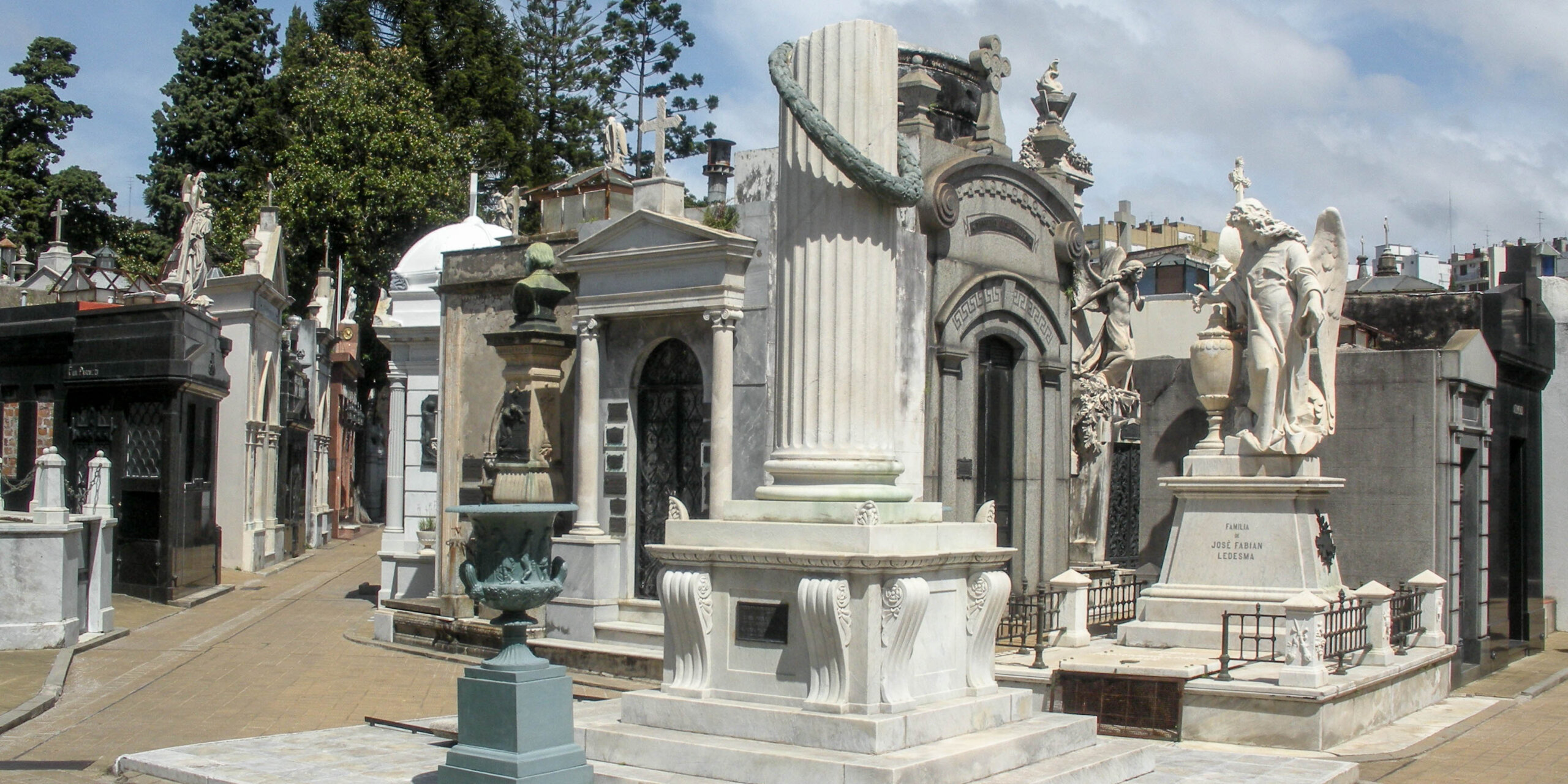 Elaborate marble mausoleums and statues line a path in La Recoleta Cemetery in Buenos Aires.