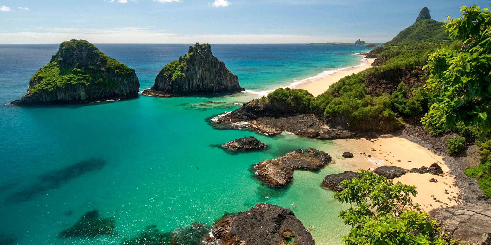 Panoramic view of Praia do Sancho in Fernando de Noronha with turquoise water and dramatic rock formations.