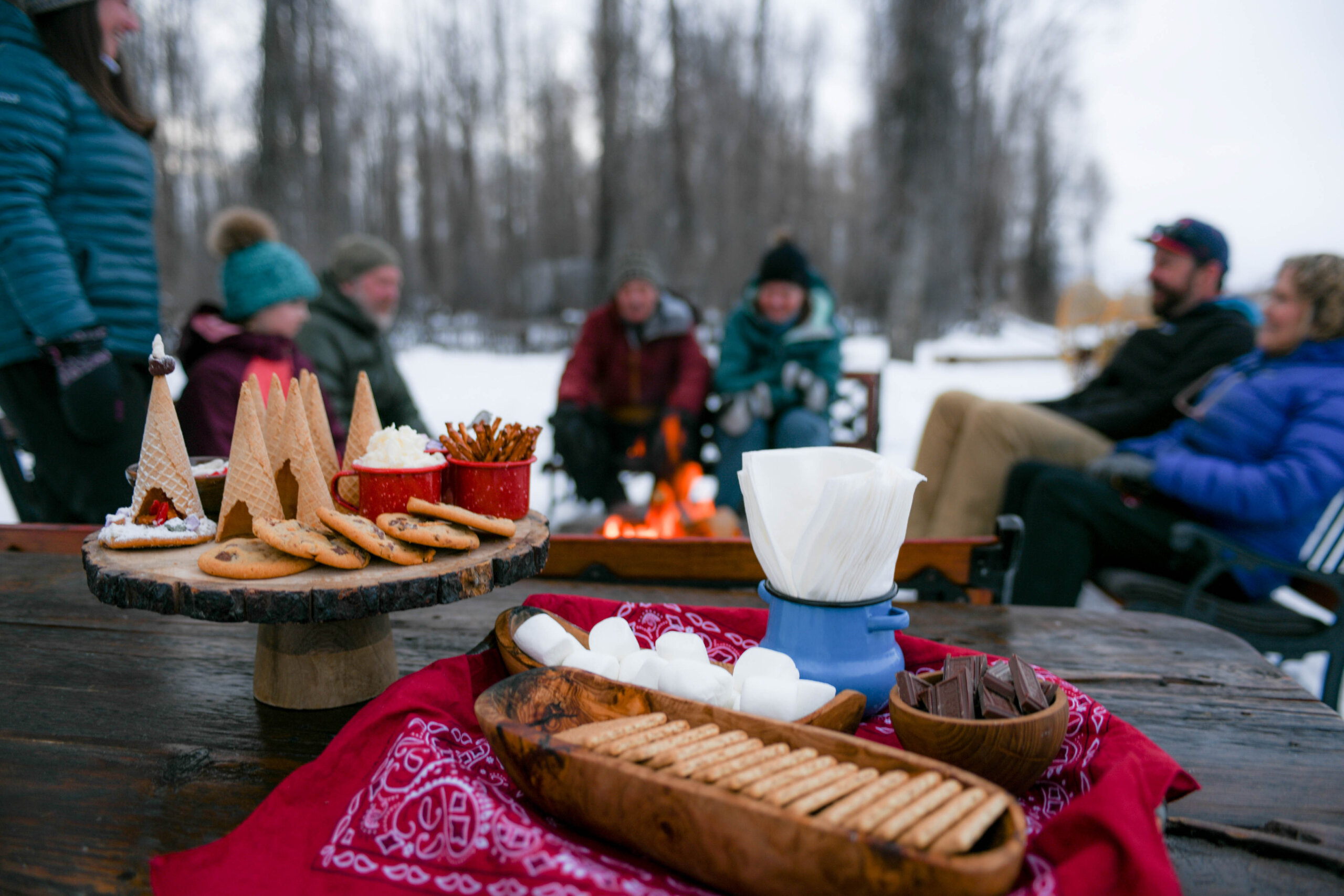 People gather around a fire in Jackson to make s'mores together in winter.