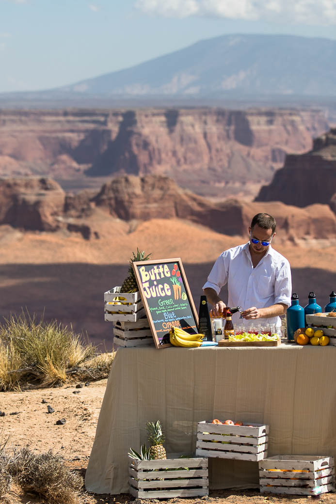 A man pours a glass at a "Butte Juice" bar atop Tower Butte.