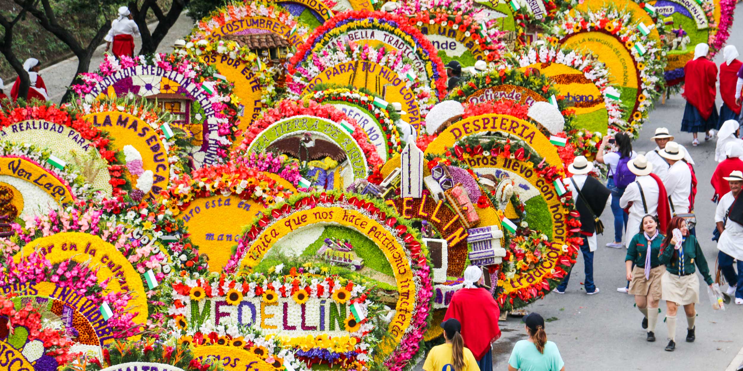 A parade of giant, colorful circular flower arrangements, or silletas, at Medellín's flower festival.