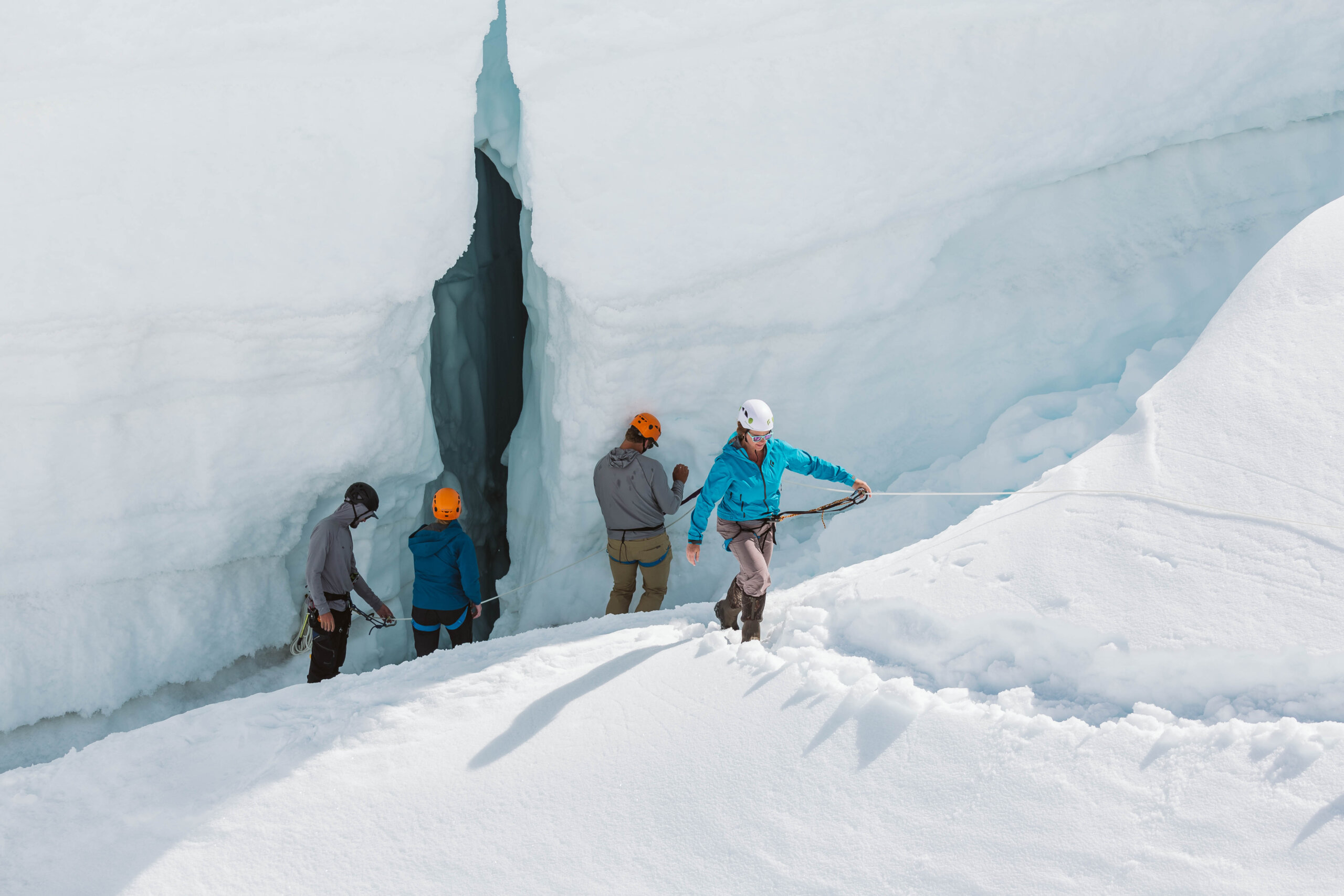 A group of friends explores glacier caverns and tunnels near Sheldon Chalet in Alaska.