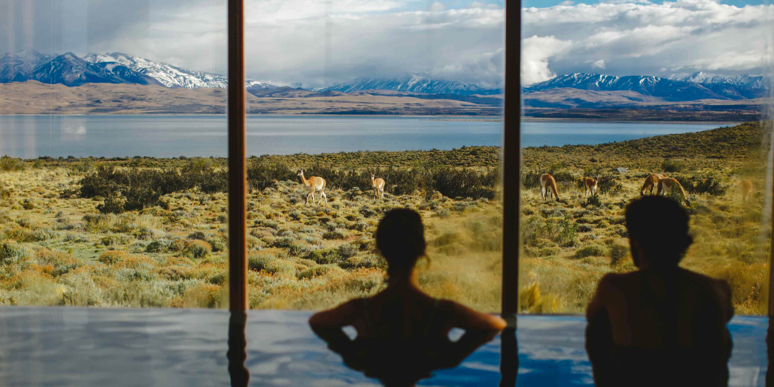 A couple watches wildlife from an infinity pool at a resort in Patagonia in Chile.