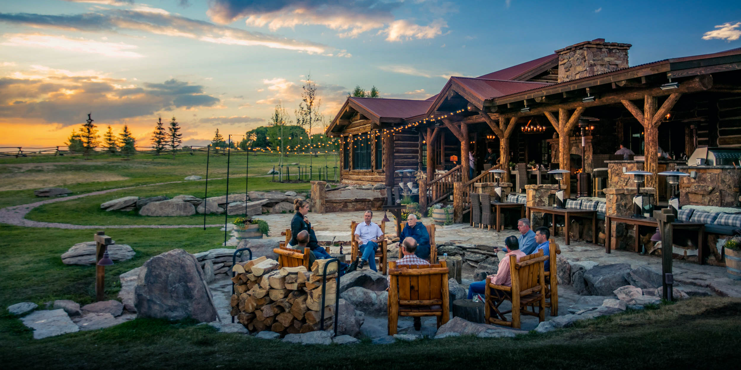 A group of friends gather on a patio at sunset at Magee Homestead