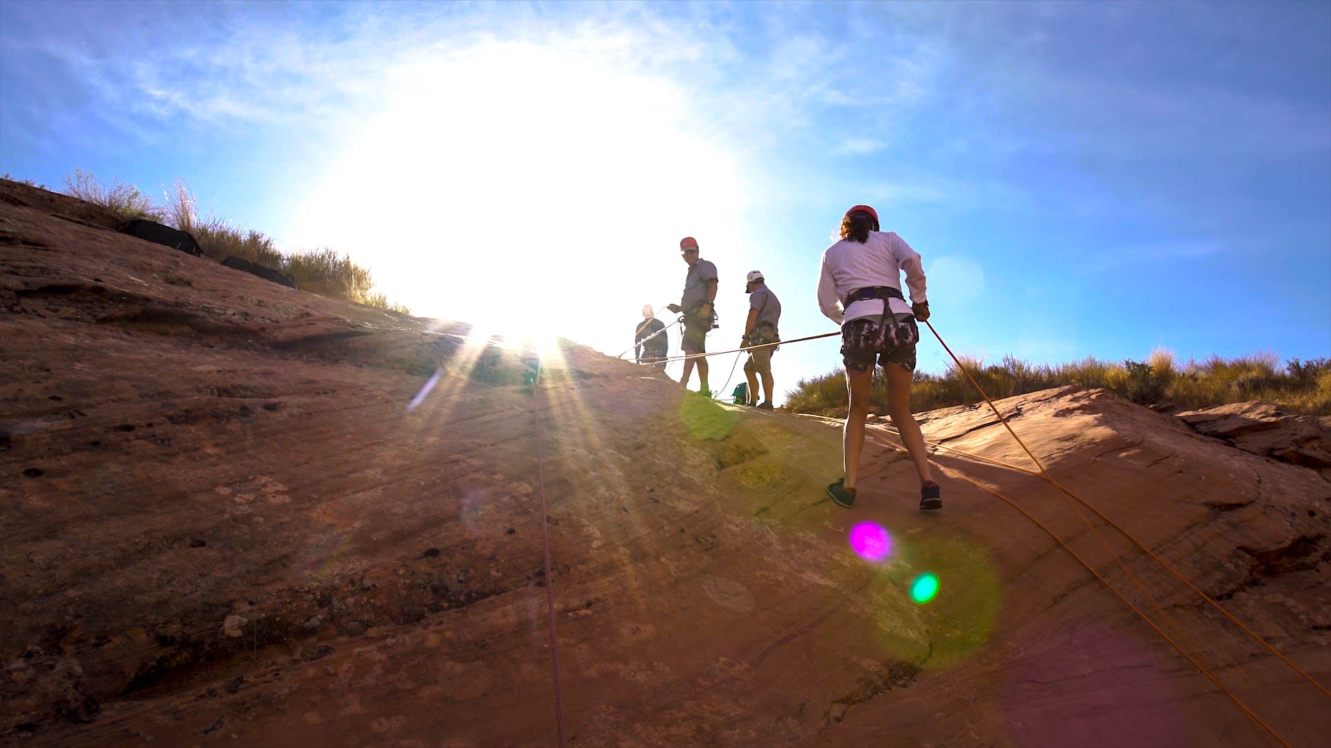 Friends rappel into a slot canyon.