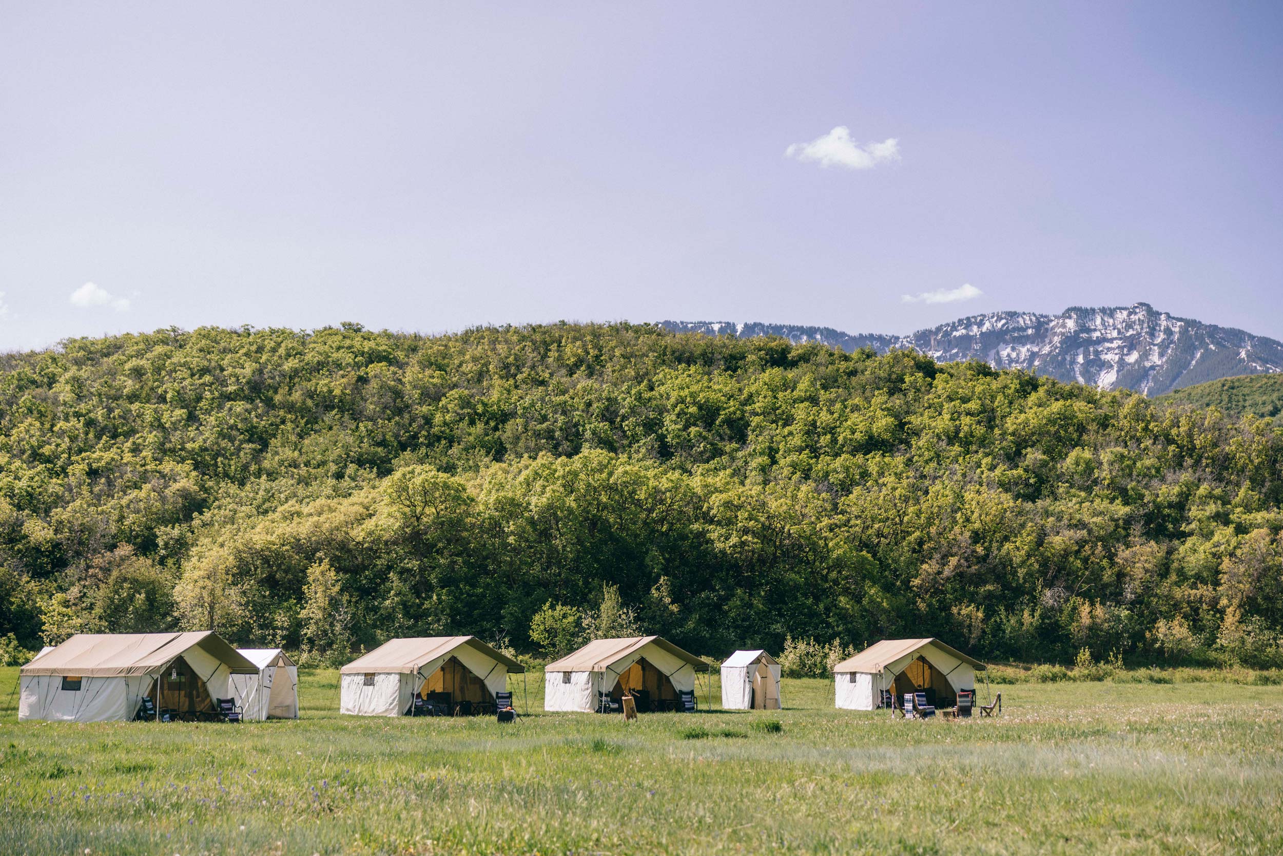 A luxury campsite in the Colorado wilderness with mountains in the back.