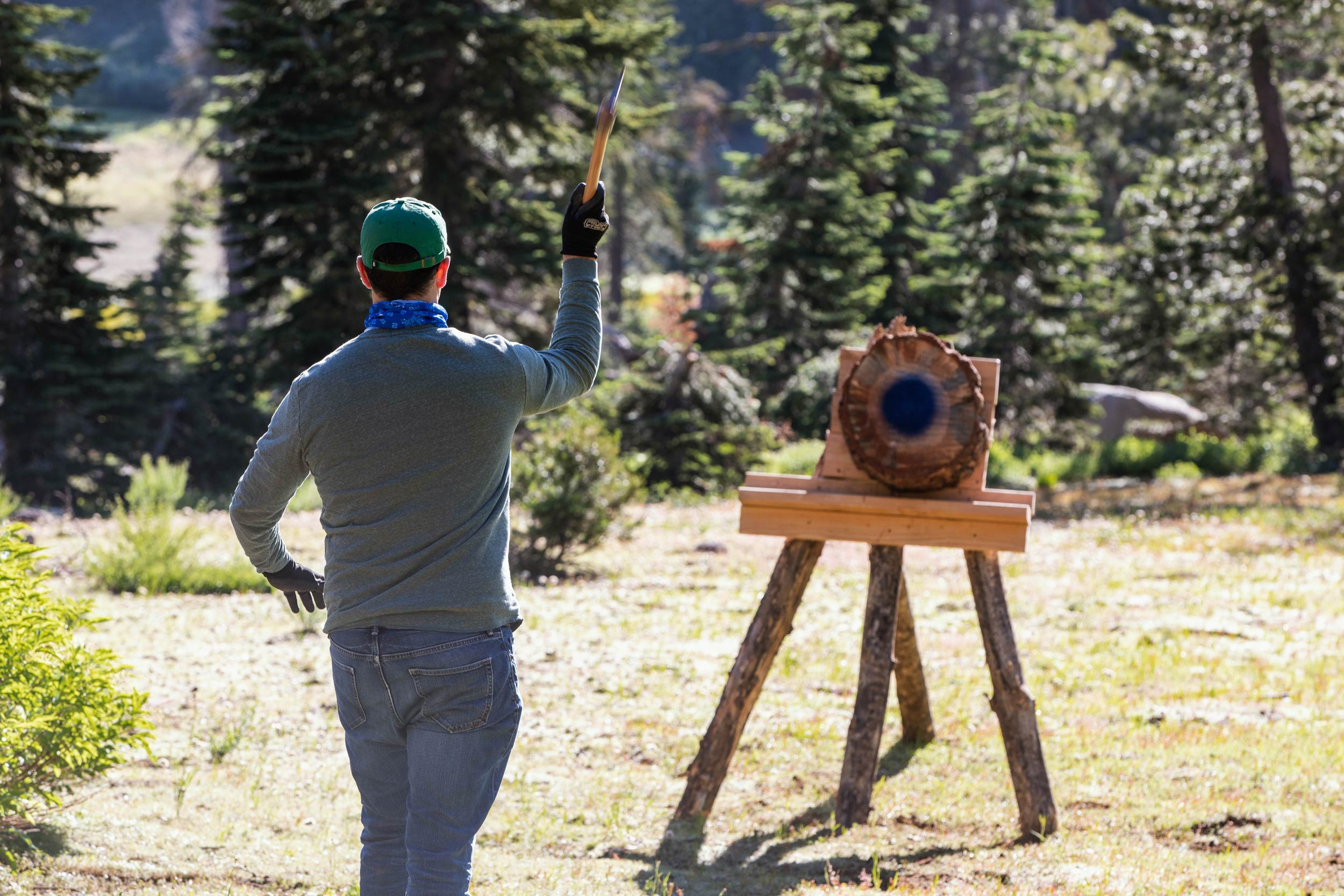A man throws an axe at a target during lumberjack games.