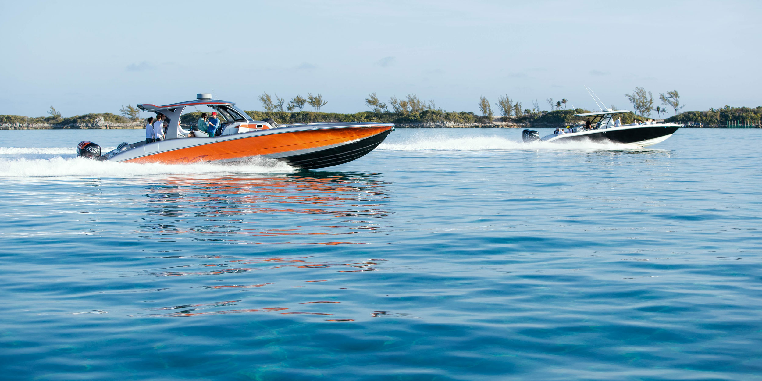 Boats race across waters in the Bahamas during a team challenge.