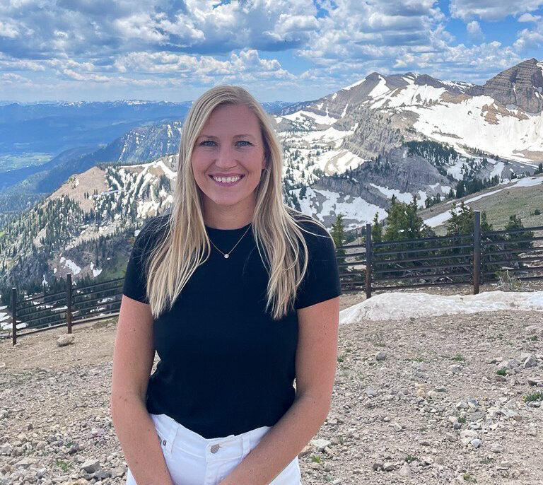 Lauren Burns stand atop a mountain in Jackson Hole, Wyoming.