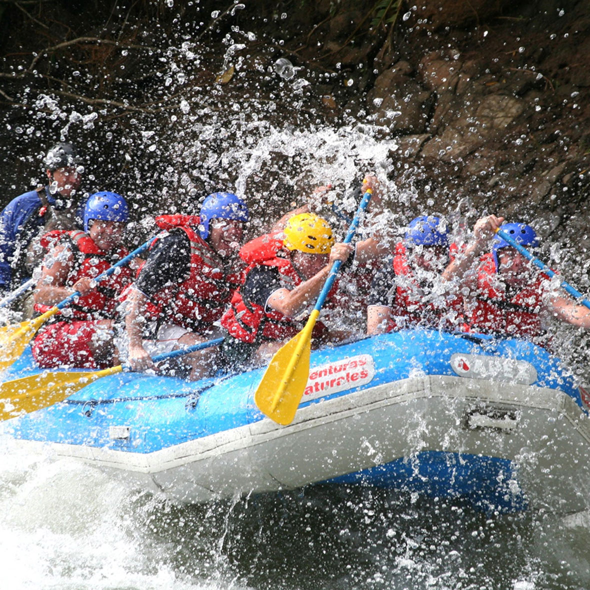 costa-rica-whitewater-rafting-2 A group of adventurers paddling hard through river rapids in Costa Rica.